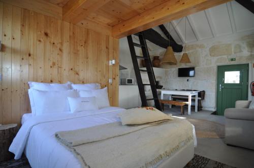 a bedroom with a large bed with a ladder at Quinta do Santinho in Amarante