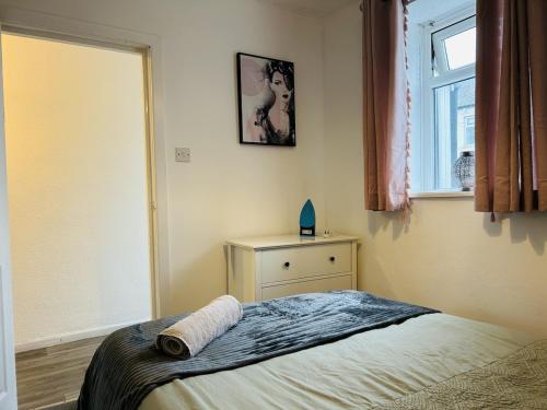 a small bedroom with a bed and a window at Cosy Flat - Over Arch in Oswaldtwistle