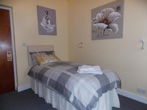 a bedroom with a bed and a flower on the wall at Sandpiper Inn B&B and Pub in Ilfracombe