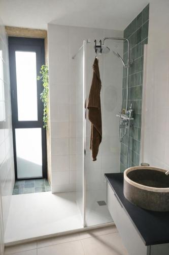 a bathroom with a sink and a glass shower at O Cabanel in Fisterra
