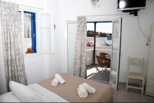 a bedroom with a bed and a table with towels at Anna Rooms Kythnos in Kanala