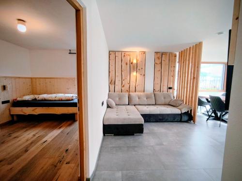 a living room with a couch and a bed at SiLENA Dolomites in Laion