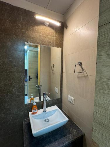 a bathroom with a sink and a mirror at Mansion Grey Studio in Ghaziabad