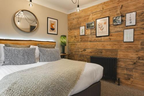 a bedroom with a wooden accent wall and a bed at Windermere Central Hotel - Central Lake District Hotel in Windermere - Ridgestone in Windermere