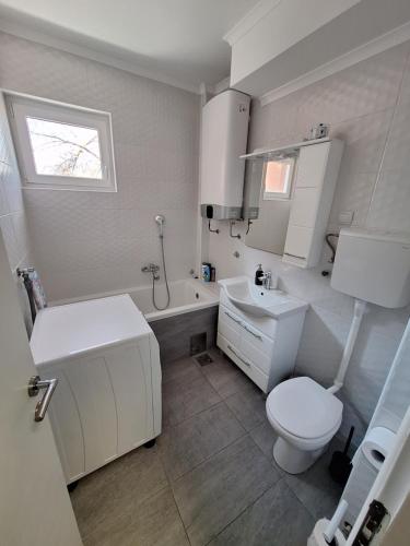 a white bathroom with a toilet and a sink at Rustic Elegance Suite in Vrbas