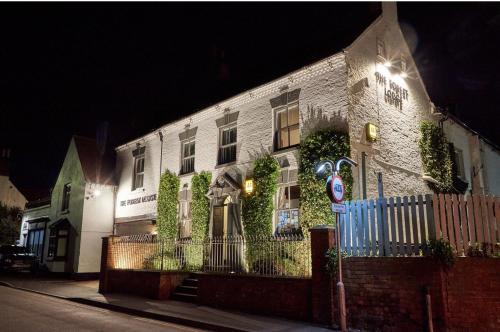 a white brick house with ivy growing on it at night at The Forest Lodge in Edwinstowe