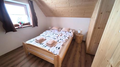 a bed in a small room with a window at Chata Relax 1 in Pribylina