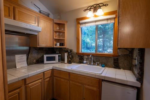 a kitchen with a sink and a microwave at Shaver Lake Village Hotel in Shaver Lake