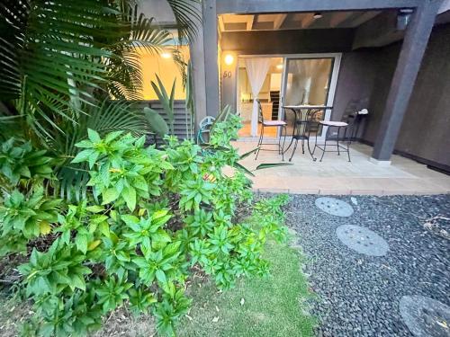 a patio with a table and chairs and plants at Beachfront 1 Bedroom Condo with Private Beach, Pool, Hot Tub in Pahala
