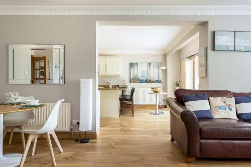 a living room with a couch and a dining room at Sandy Shores - Moments from Blue Flag Sandbanks Beach in Poole