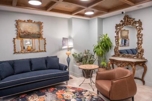 a living room with a blue couch and a mirror at Treadwell Mansion in Portsmouth