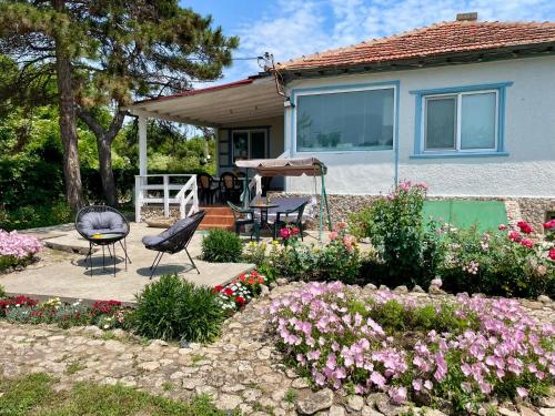a house with a table and chairs in a garden at Vila 'Anna' in Krapets