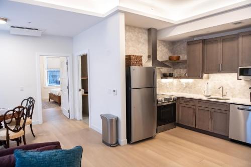 a kitchen with a stainless steel refrigerator and a table at Treadwell Mansion in Portsmouth