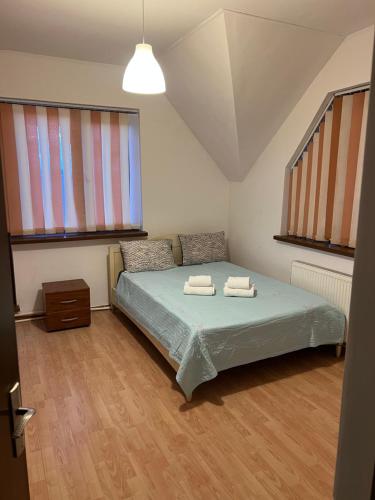 a bedroom with a bed with two towels on it at Vila Maria in Roman