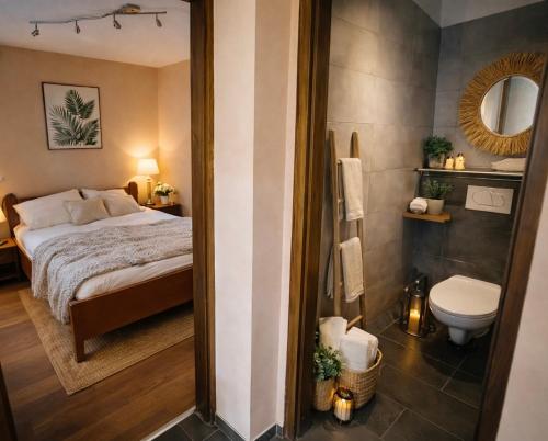a bedroom with a bed and a bathroom with a toilet at Happy Home Apartman in Siófok