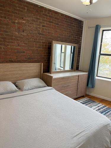 a bedroom with a bed and a brick wall at Weehawken Apartment NYC Skyline in Weehawken