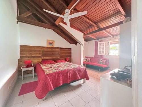 a bedroom with a bed and a ceiling fan at Villa Soleïa in Gourbeyre