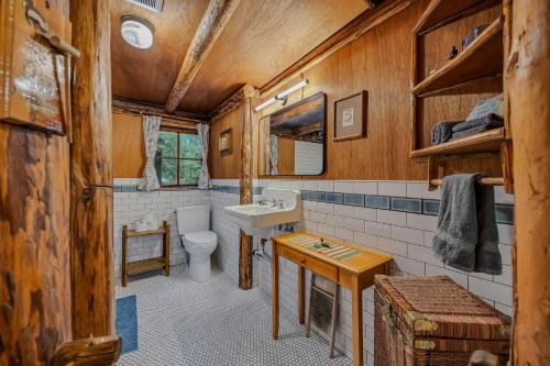 a bathroom with a toilet and a sink at Mountain Air Cabin in Welches