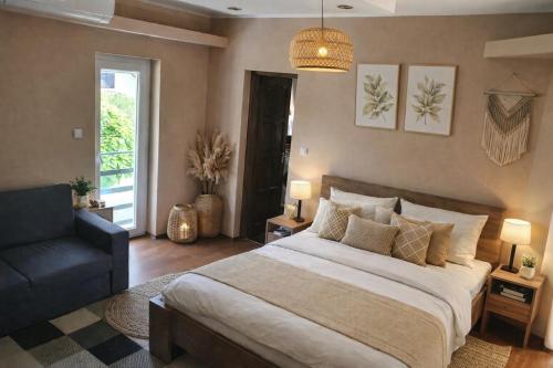a bedroom with a large bed and a chair at Happy Home Apartman in Siófok