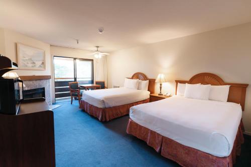 a hotel room with two beds and a desk at The Monarch Resort in Pacific Grove