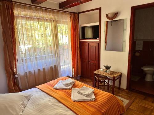 a bedroom with a bed with two towels on it at Raza Soarelui in Moieciu de Sus