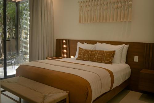 a bedroom with a large bed and a balcony at Casa Edén in Xpu Ha