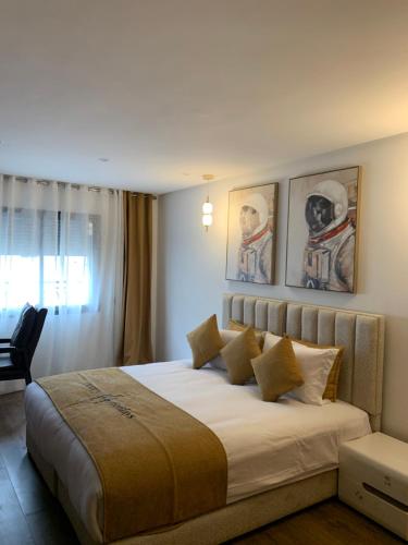 a bedroom with a large bed with paintings on the wall at Sky View by Luxurious Holidays in Rabat