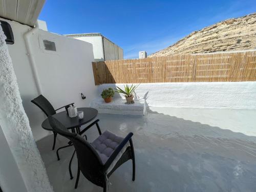 a patio with a table and chairs and a fence at Kritamos Beach House - Near the Beach with Easy Parking in Matala