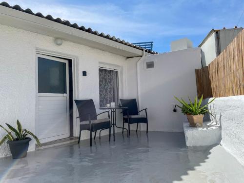 a patio with a table and chairs on a balcony at Kritamos Beach House - Near the Beach with Easy Parking in Matala