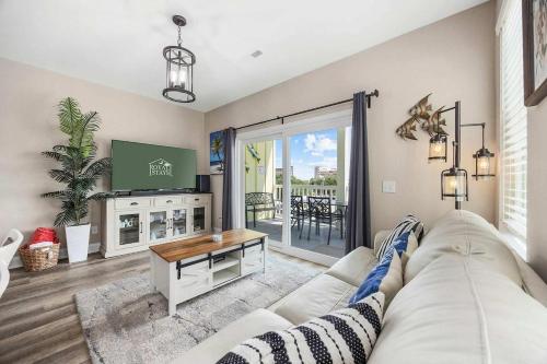 a living room with a white couch and a tv at Sunshine Derby - 1 Block to Beach- Garage EV Cha in Myrtle Beach