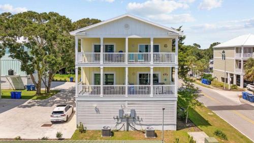 a white and yellow house with a balcony at Sunshine Derby - 1 Block to Beach- Garage EV Cha in Myrtle Beach