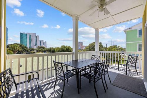 a patio with a table and chairs on a balcony at Sunshine Derby - 1 Block to Beach- Garage EV Cha in Myrtle Beach