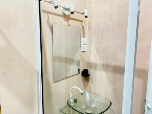 a mirror and a glass bowl on a wall at Chanco Beach Hotel and Coworking - Negombo in Negombo