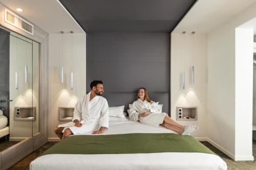 mężczyzna i kobieta siedzący na łóżku w obiekcie Cézanne Hôtel w Cannes