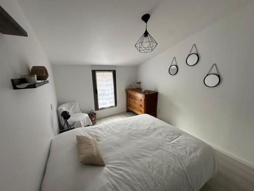 a white bedroom with a bed and a window at Appartement terrasse en ville in Blois