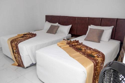 two beds sitting next to each other in a room at Elclassico Villa in Nyanda