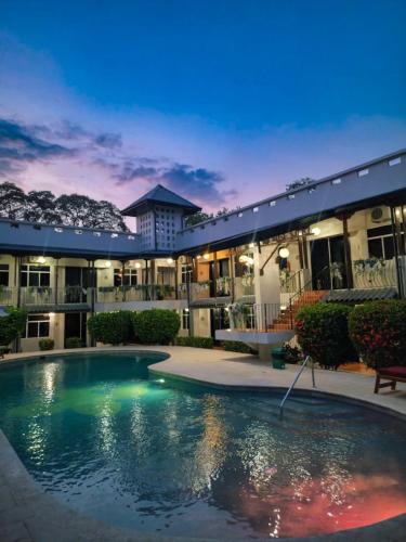 a swimming pool in front of a building at night at Parti Gras Hotel & Villas en Playa Potrero in Potrero