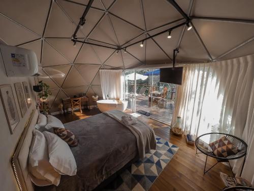 a bedroom with a large bed in a tent at GOAT LODGE Domo Pitanga in Ibiúna