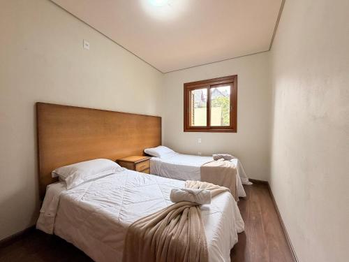 a bedroom with two beds and a window at Apto Rua Coberta Gramado in Gramado