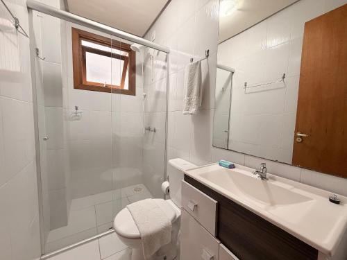 a bathroom with a shower and a sink and a toilet at Apto Rua Coberta Gramado in Gramado