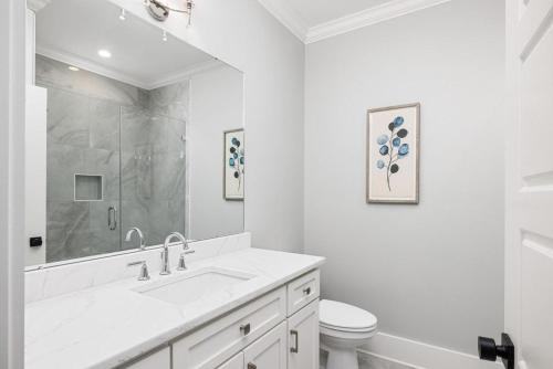 a white bathroom with a sink and a toilet at Jungle House-Heated Pool-Pet Friendly-Luxury in Edisto Island