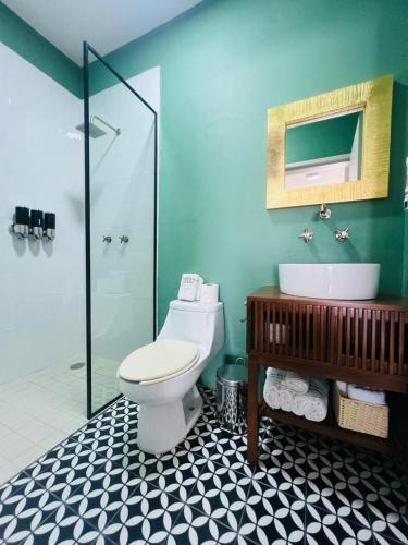 a bathroom with a toilet and a sink and a shower at Kundera Hotel Boutique in Colima