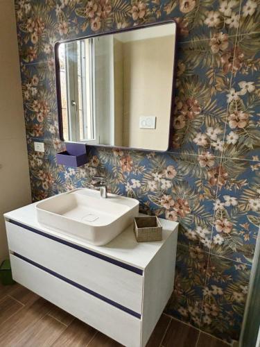 a bathroom with a sink and a mirror on a wall at NessunConfine Casa Laura in Santa Giuletta