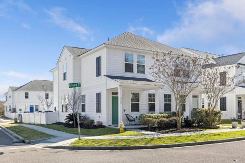 a white house with a green door on a street at Creekside Bungalow-Park Circle-15m dtwn CHS in Charleston