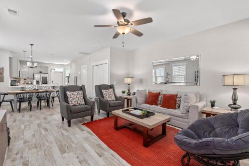 a living room with a couch and chairs and a table at Creekside Bungalow-Park Circle-15m dtwn CHS in Charleston