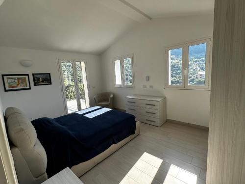 a bedroom with a bed and a desk and windows at House in Paradise in Moneglia