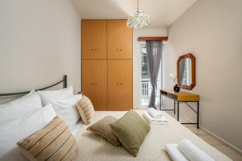 a bedroom with a bed with pillows and a mirror at Flora Beach House in Kremasti
