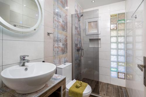a bathroom with a sink and a toilet at Flora Beach House in Kremasti