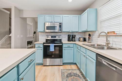 a kitchen with blue cabinets and a stove top oven at Boho SoCo- 8 mins to Credit One, 20 mins to DTWN in Charleston