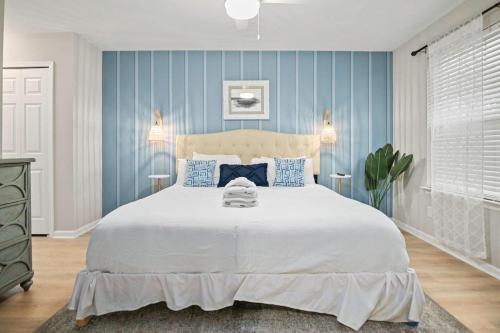 a bedroom with a large white bed with blue walls at Boho SoCo- 8 mins to Credit One, 20 mins to DTWN in Charleston